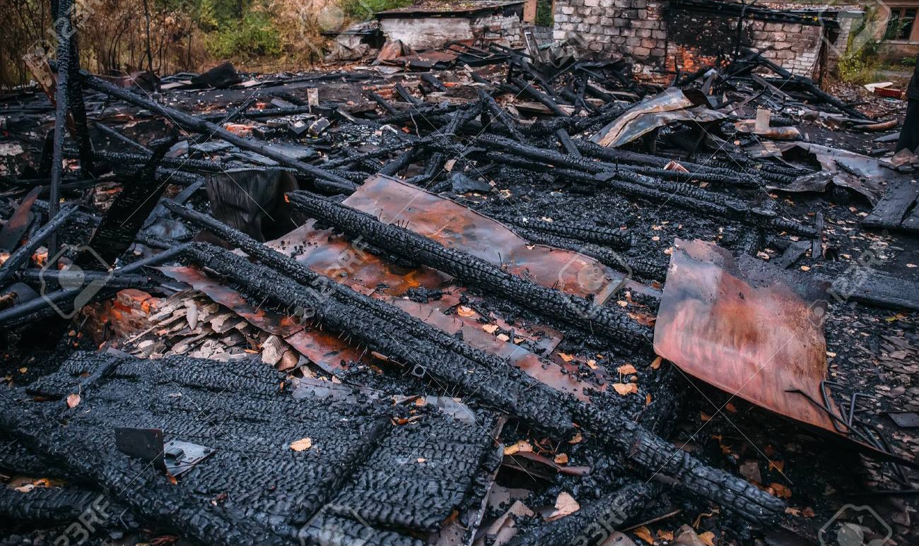 87866552-burned-house-ruins-of-destroyed-building-by-fire-ash-and-coal-arson-concept
