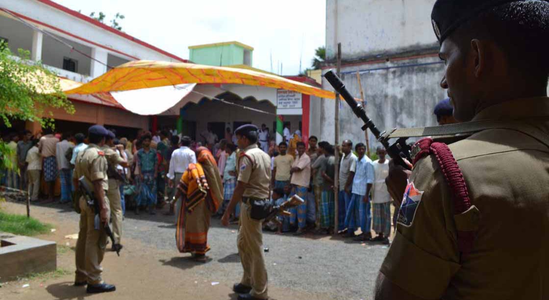 CRPF jawan watching a voter during 4th phase panchayat poll at Birbhum district in West Bengal on 22 July 2013. (Photo: IANS)